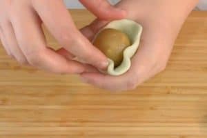 Wrap the filling balls with a thin piece of dough