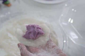 Place the purple halaya paste in the middle of the rice cake piece before wrapping it into a ball