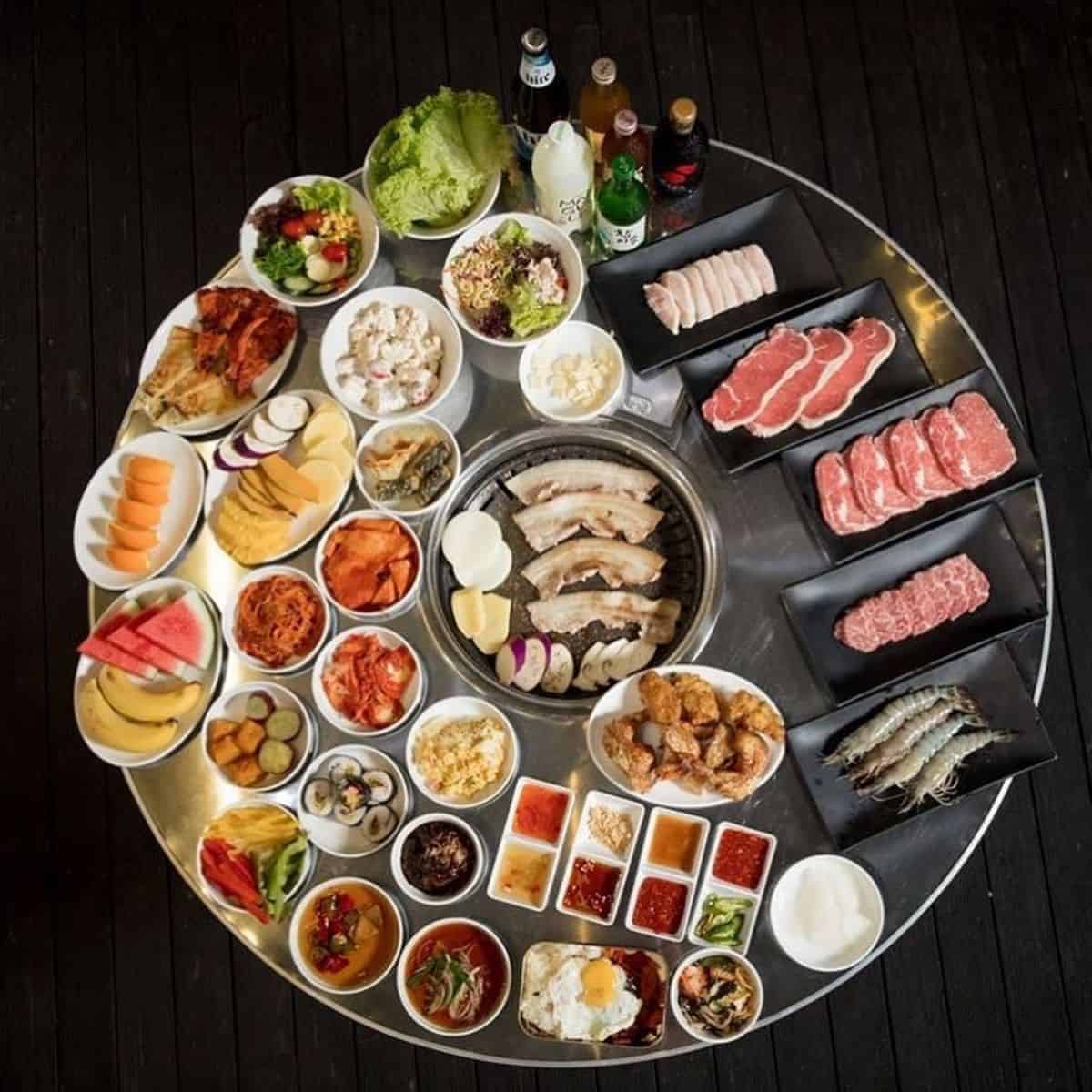 A table different meats and side dishes for Korean BBQ