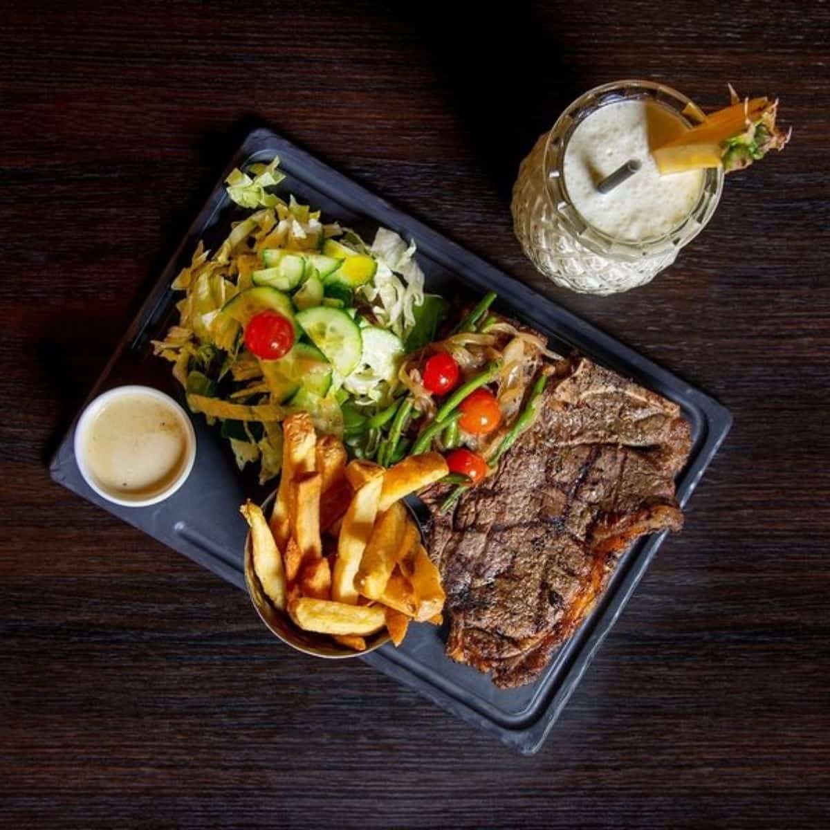 steak with lettuce, cucumber, tomatoes and chips