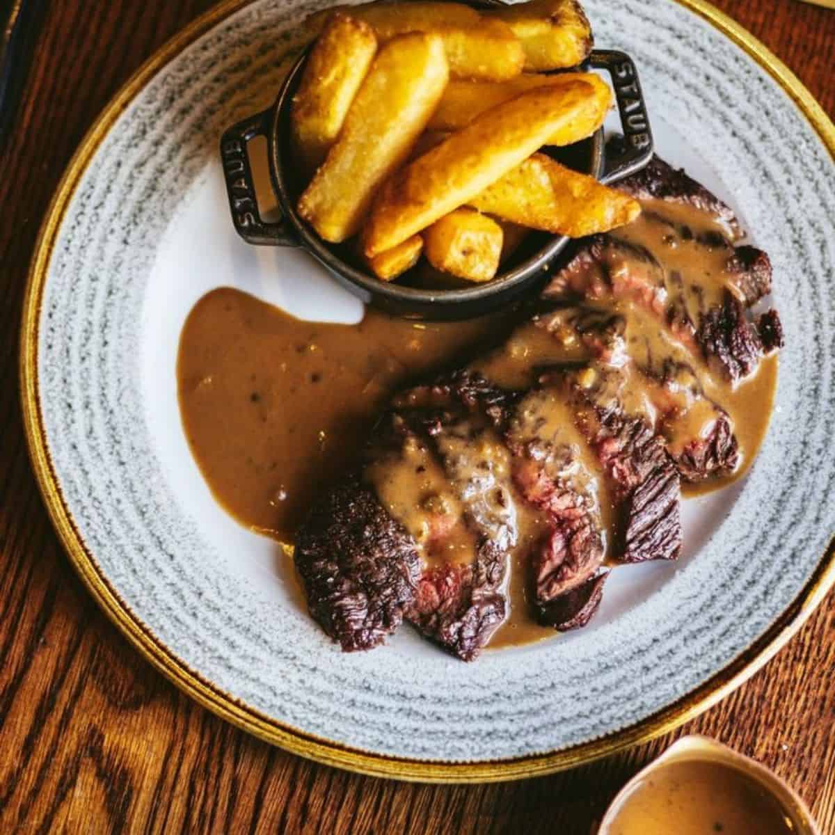 Steak served with a seasonal sauce and chips on the side The Coal Shed