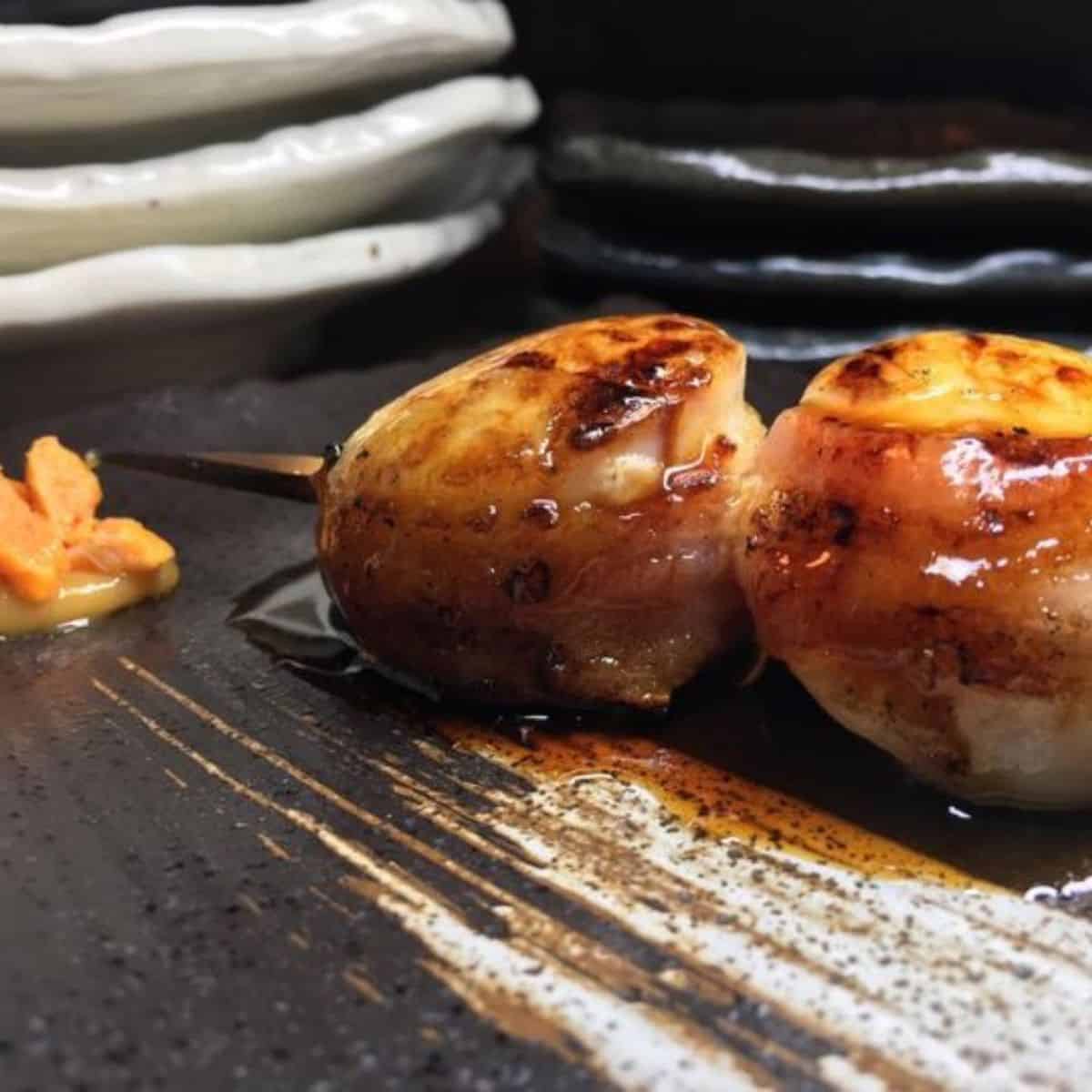 Takoyaki with scallops and bacon in skewers drizzled with sauce Bincho Yakitori