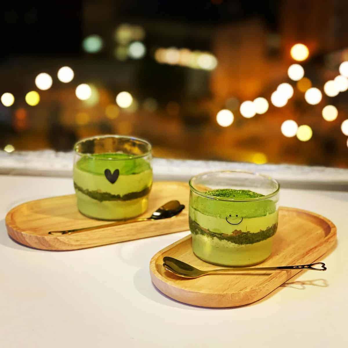 Two glasses of green tea Italian dessert with a heart shape spoon on the side