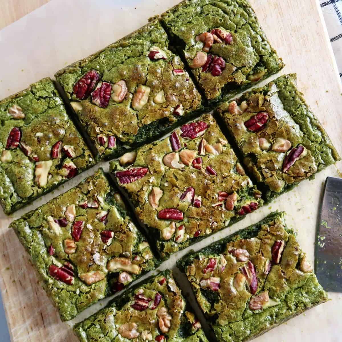 Matcha Brownies overly baked on top with white chocolate and brownish red garnishes