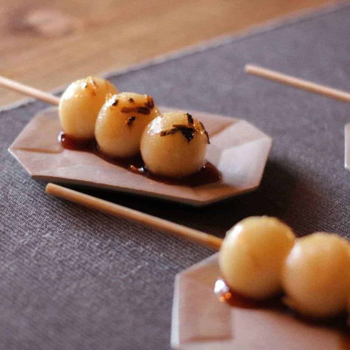 Japanese Dango that are elegantly presented in a ceramic, rectangular plate