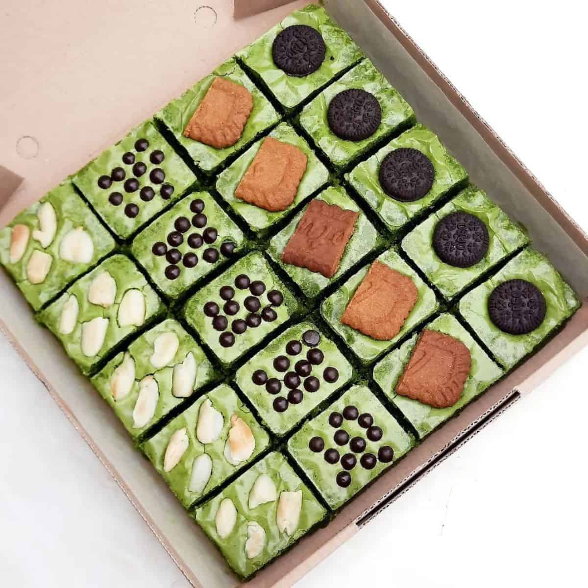 One layer of green cakes with mixed toppings of peanuts, chocolates, and biscuits