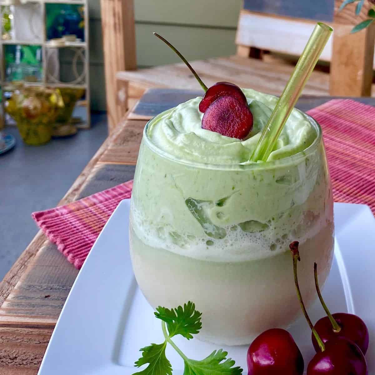 Luscious green creamy drink with cherries as toppings.