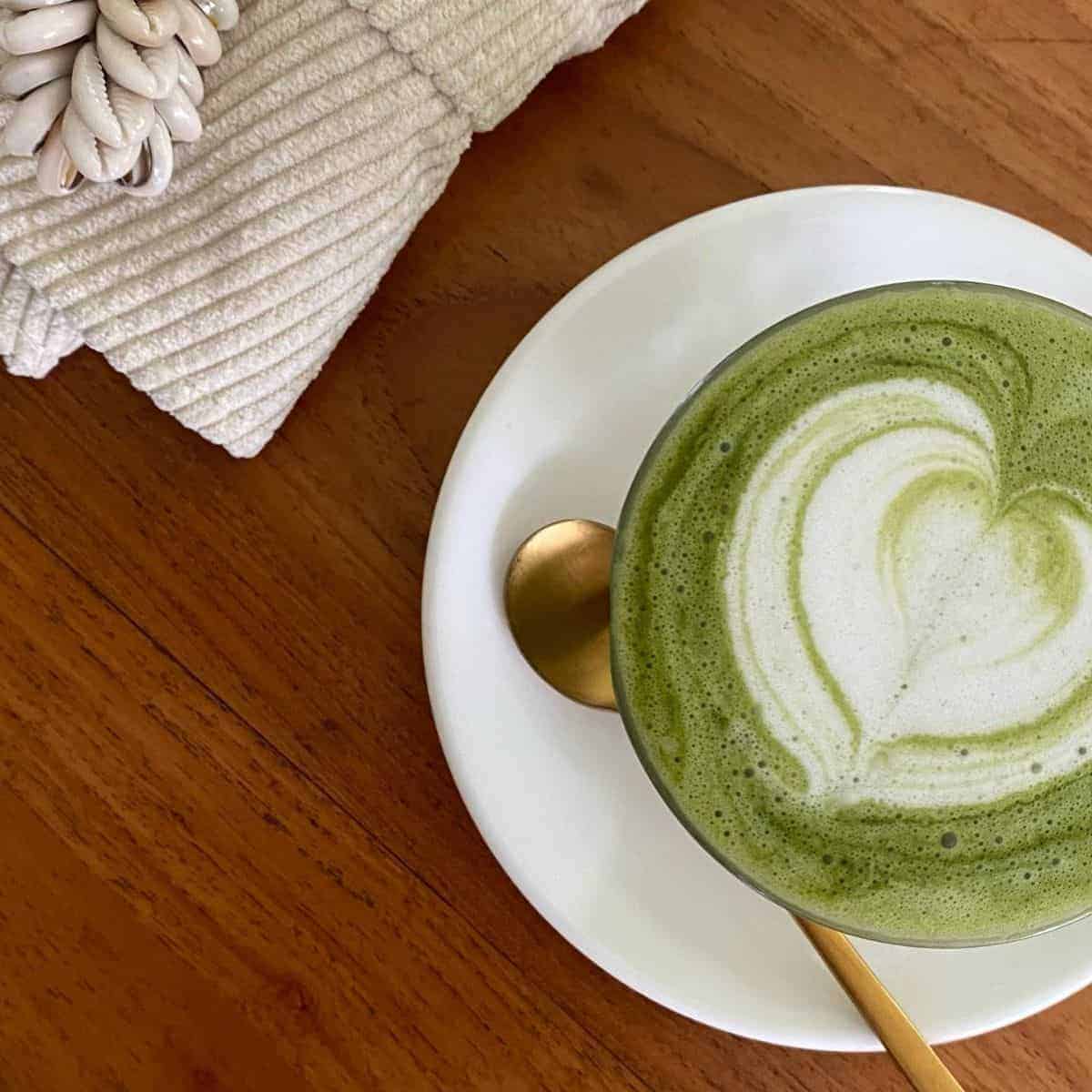 Top view of your favourite Matcha Latte cup with a golden spoon