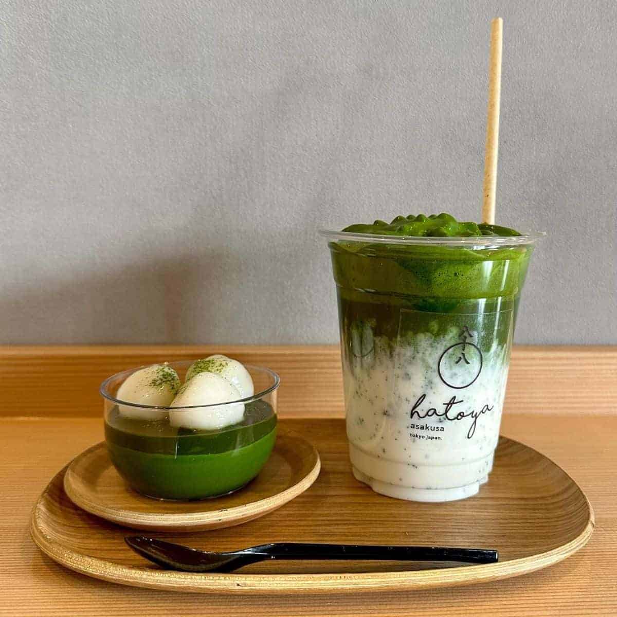 A beautiful serving of gree tea beverage with straw and pudding with black spoon