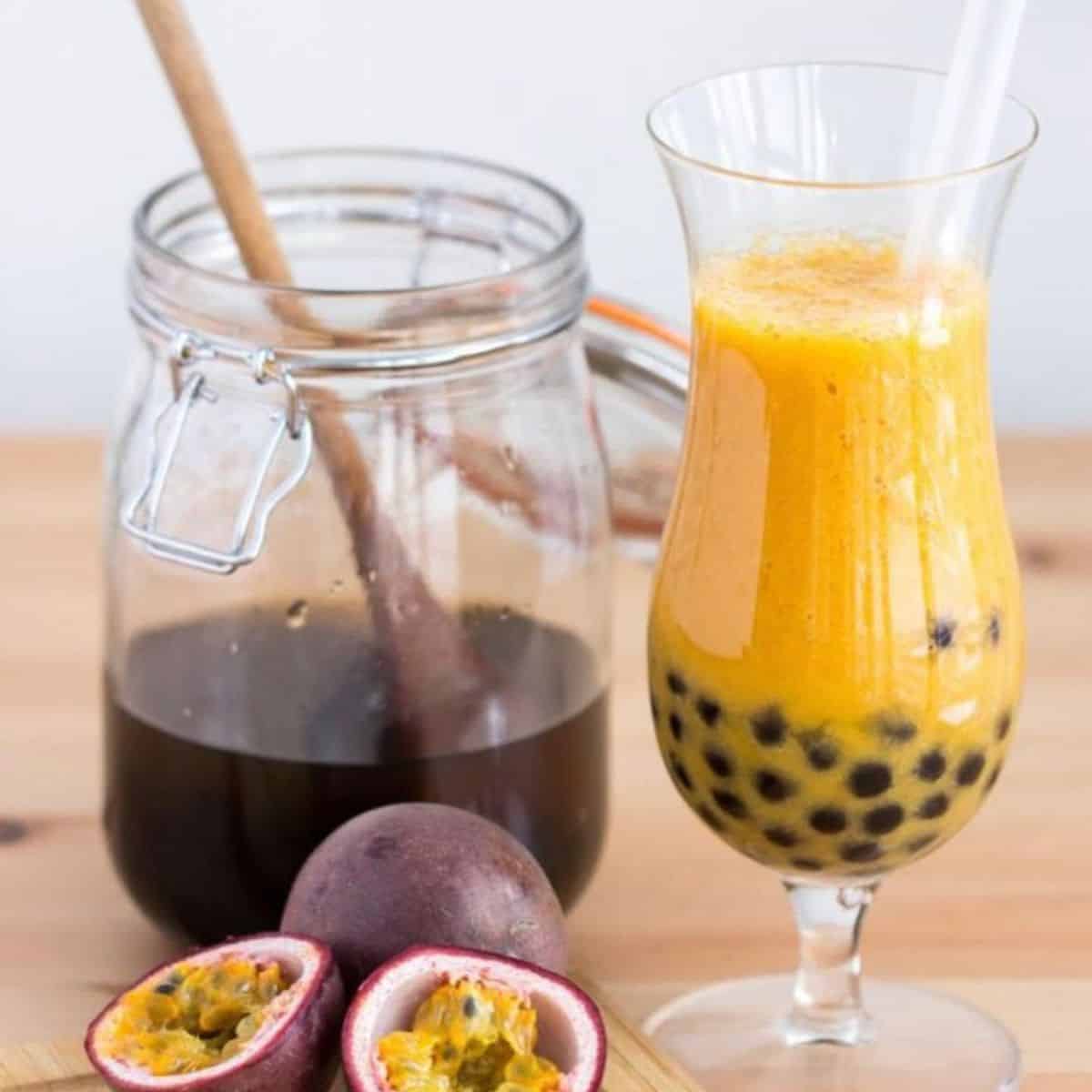 Passiona fruit boba drink in a glass and slices of fresh passion fruit