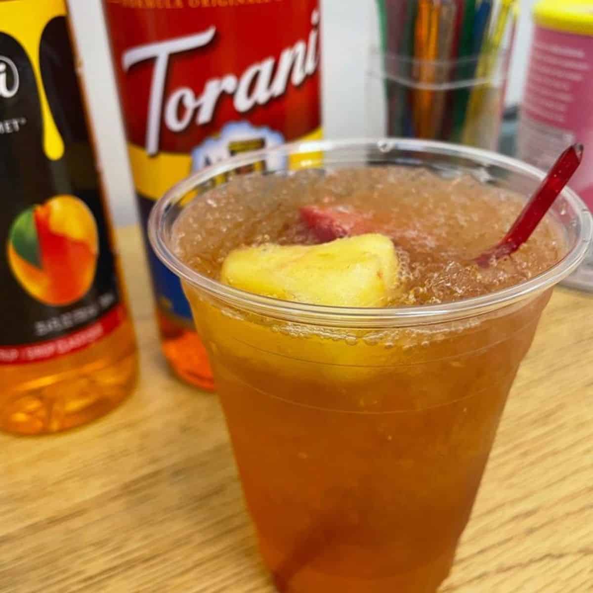 Cold tea drink with crushed ice and peach syrup as a sweetener
