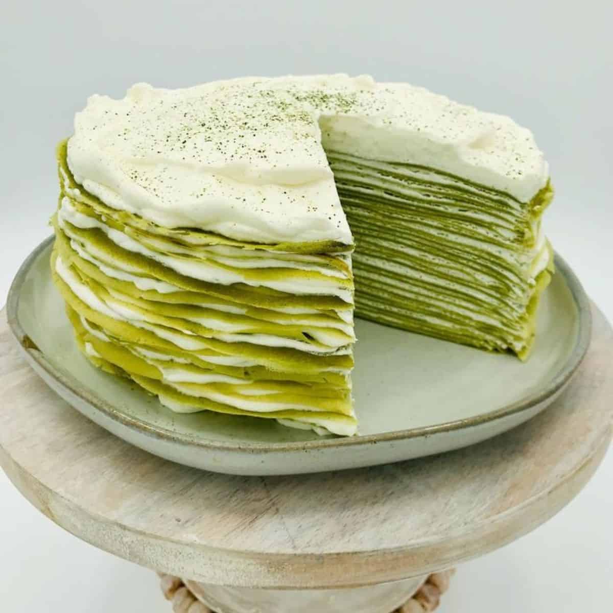 A display of delicious green Japanese dessert with thick, white cream in between each layer