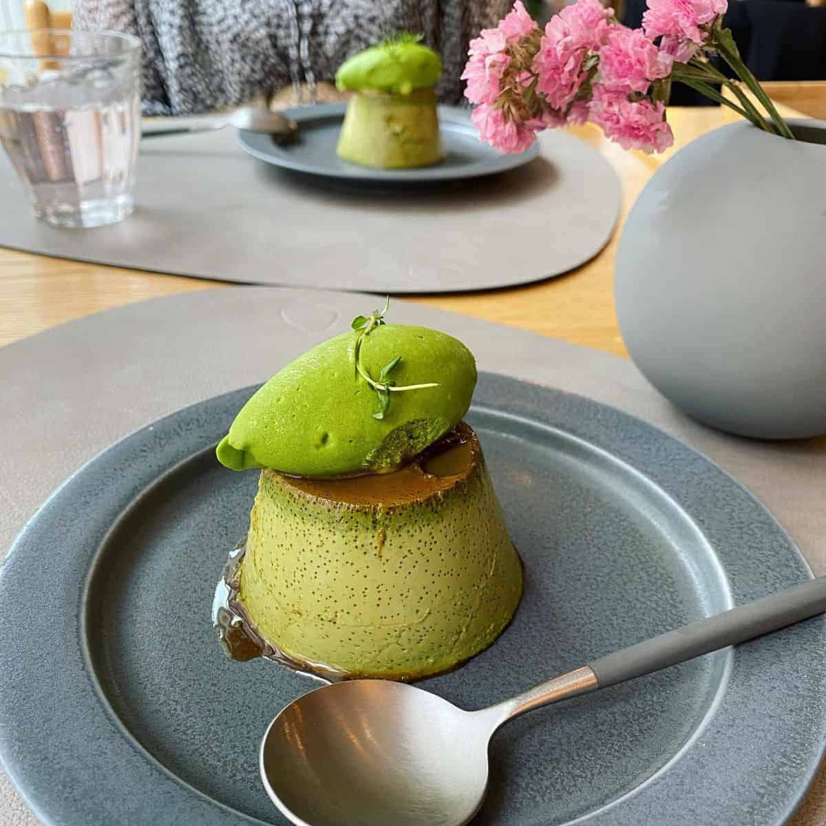 Sumptuous matcha pudding with brownish sauce and a green decor on top