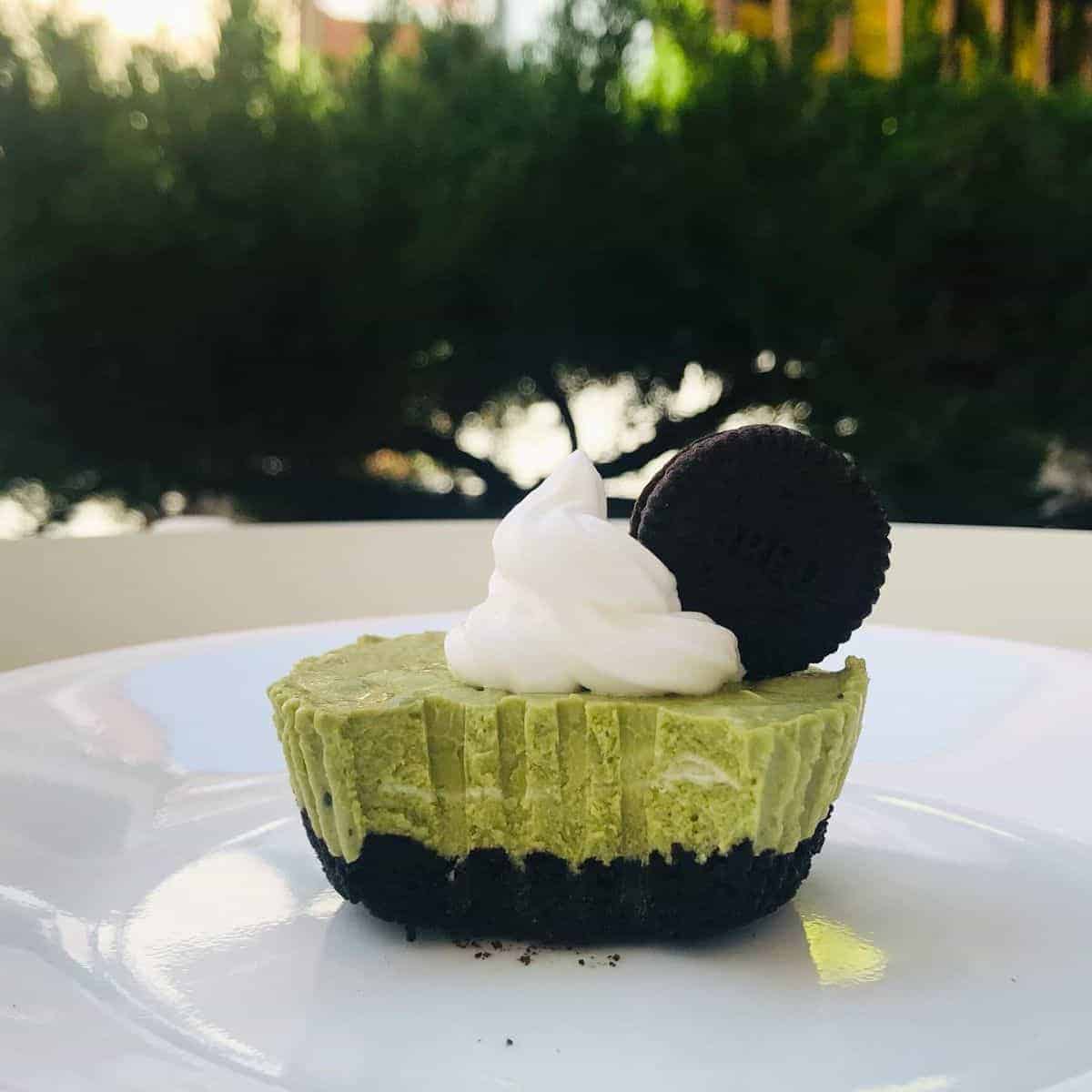 Matcha Oreo Cheesecake with a swirling white cream as decor