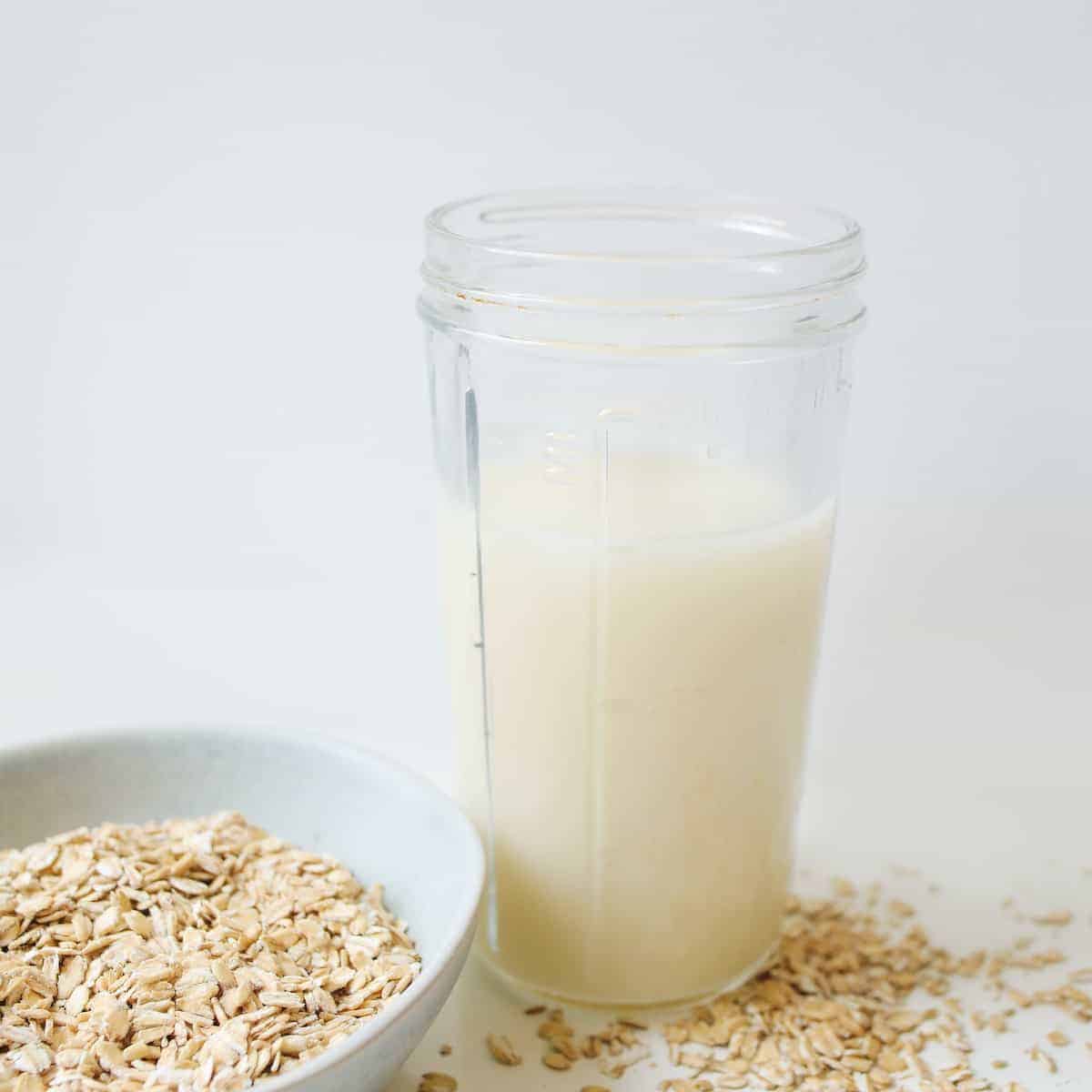 Oats in a white bowl and a glass of milk