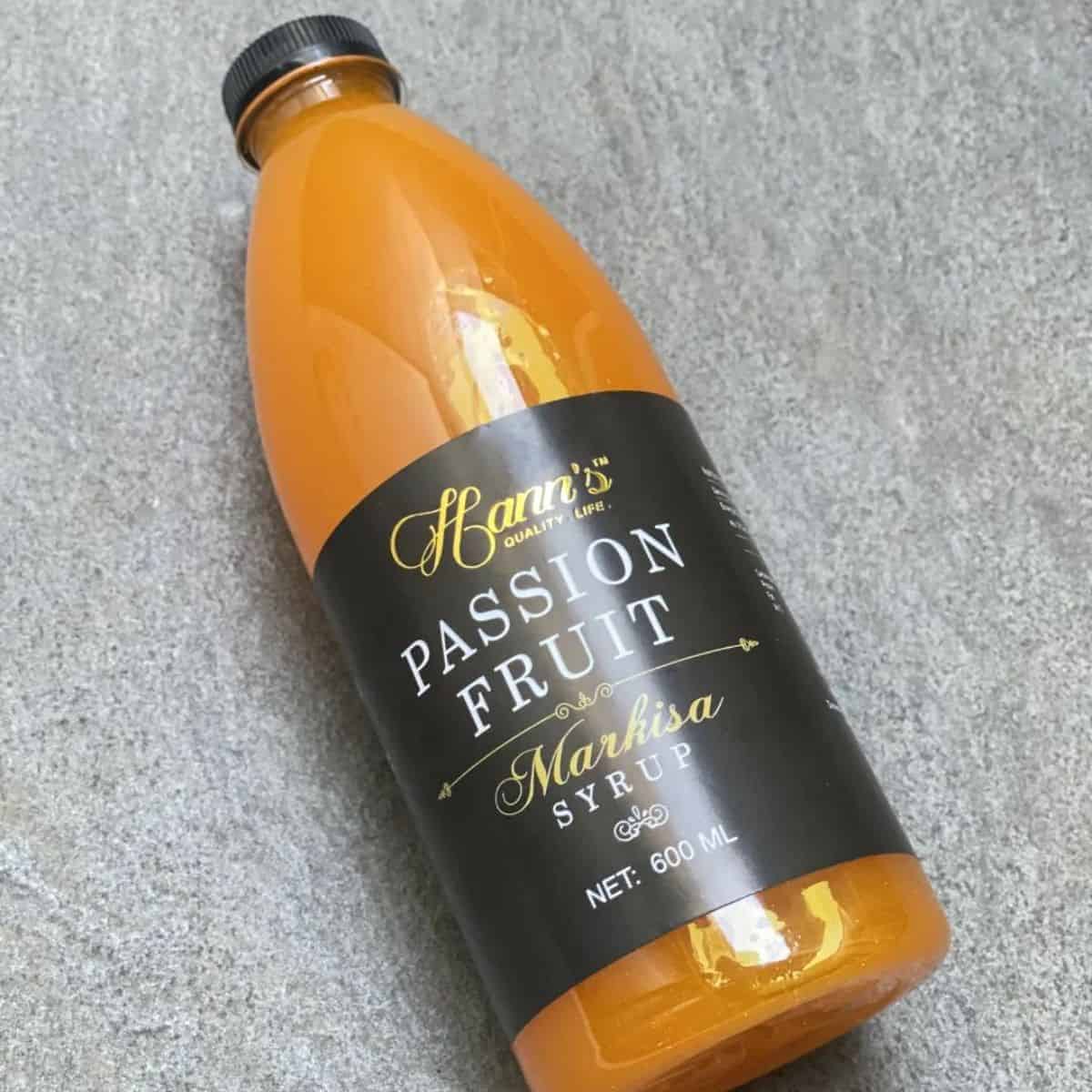 Orangey liquid sweetener in a large bottle with black labelling