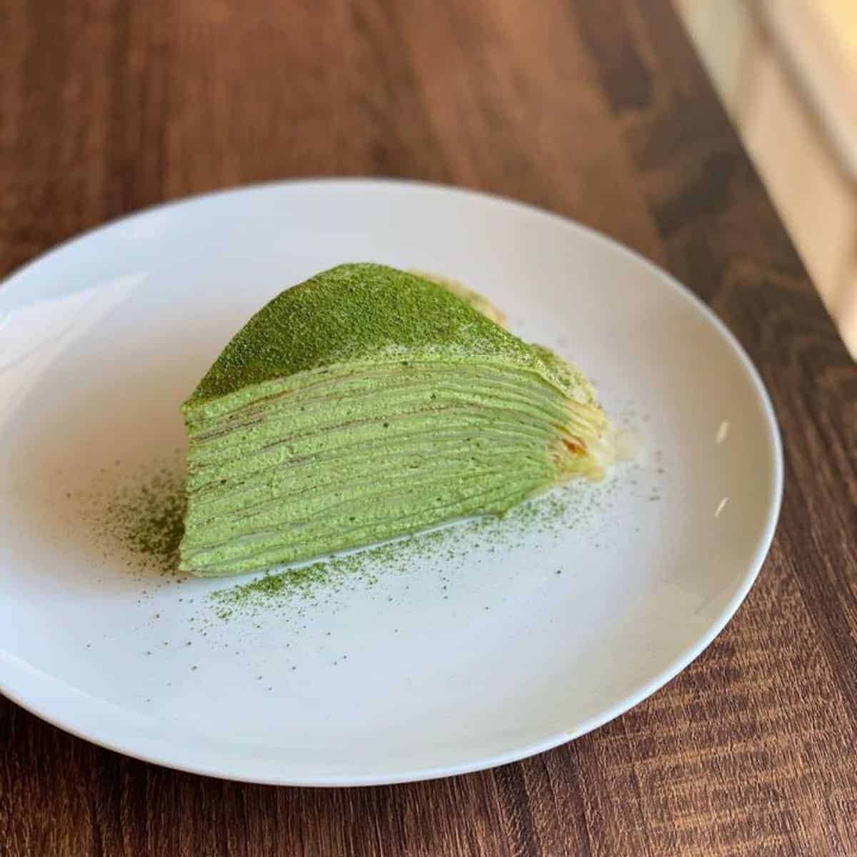 Tempting slice of a Green Tea Crepe Cake with a smooth and soft texture in a curved design