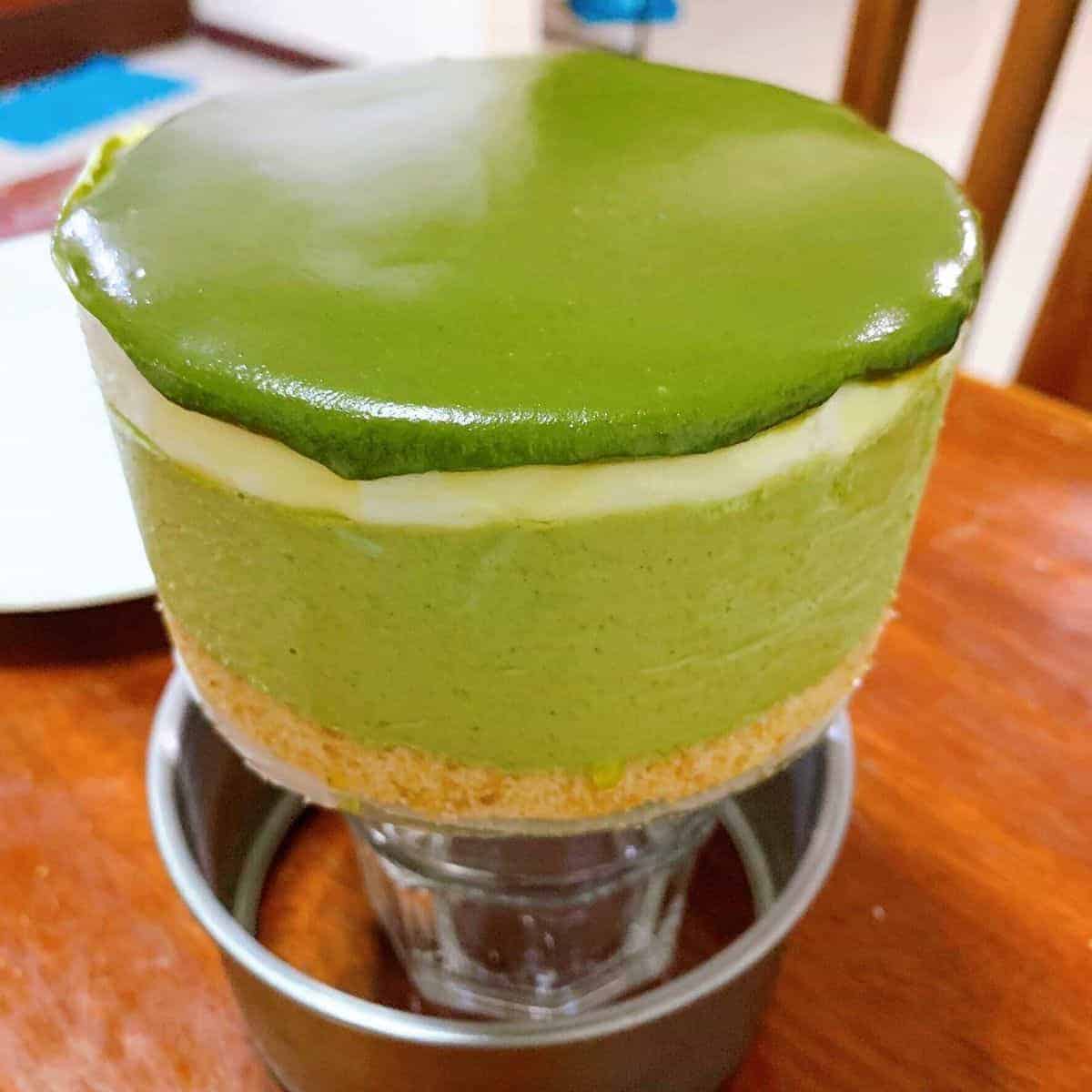 A thick layer of a baked goodie with a smooth, green ganache on top