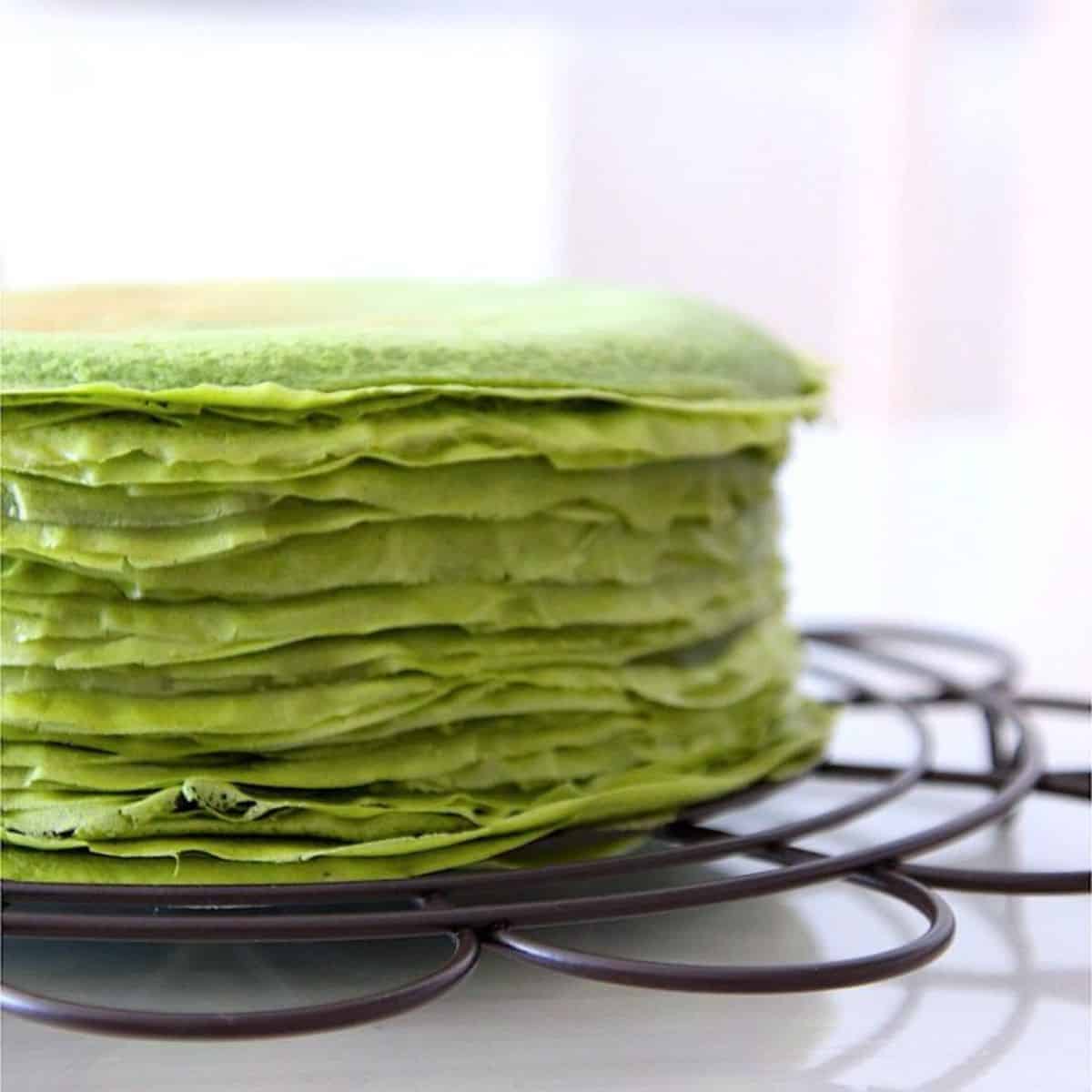  Thin layers of green coloured crepes placed on a white table