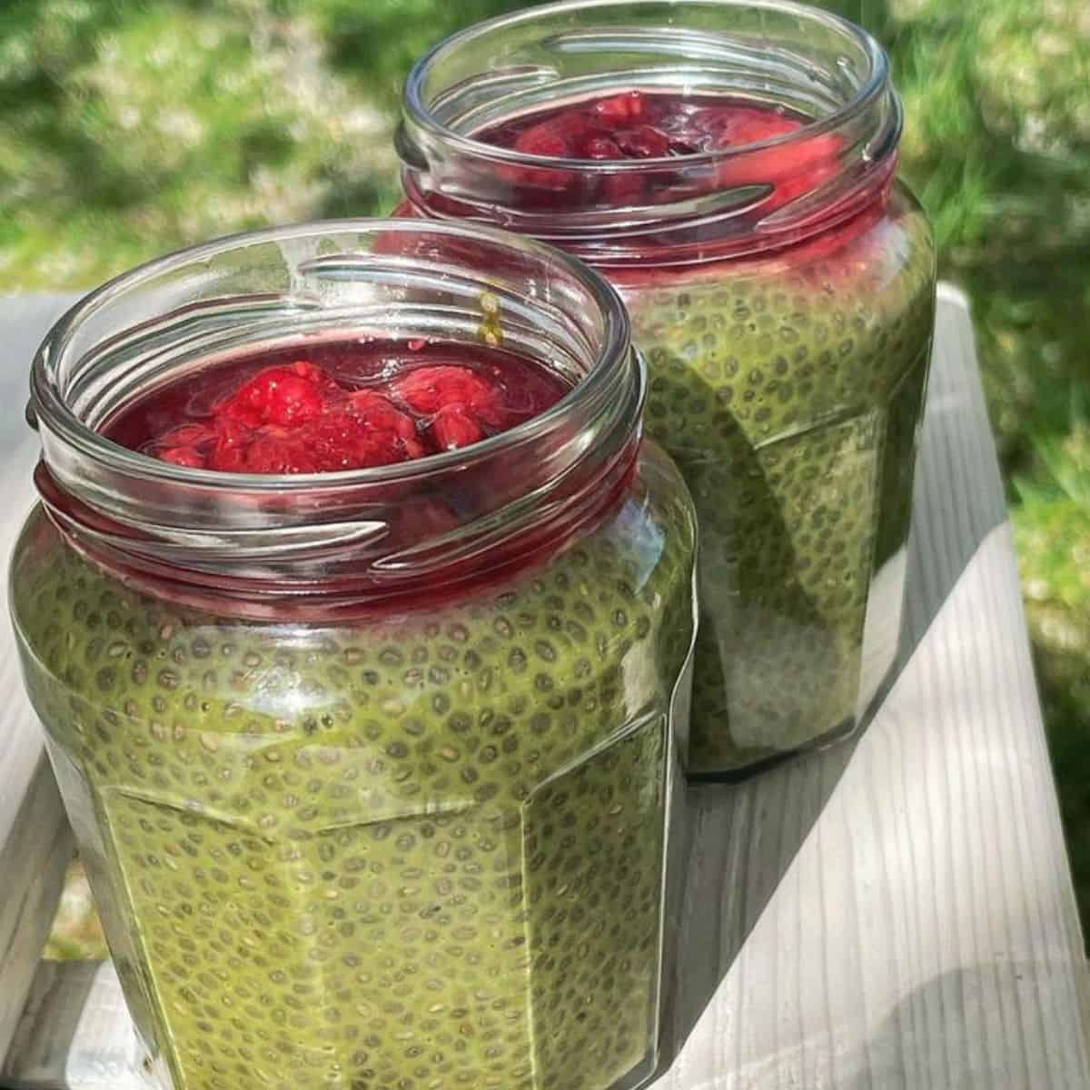 Two bottles of delicious green tea chia dessert with raspberries on top