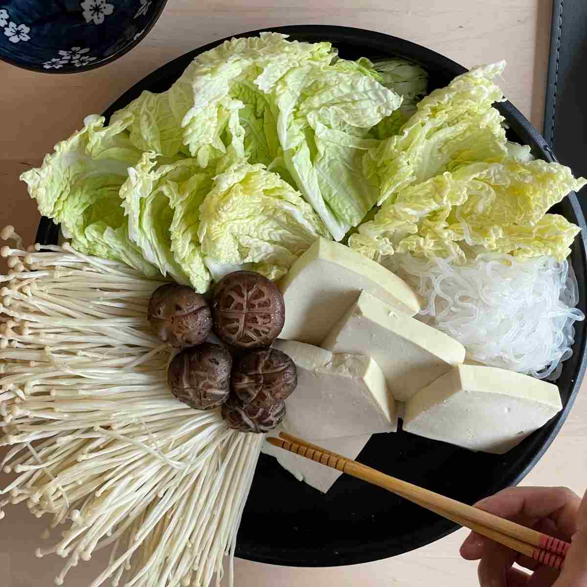 place sukiyaki ingredients in hot pot