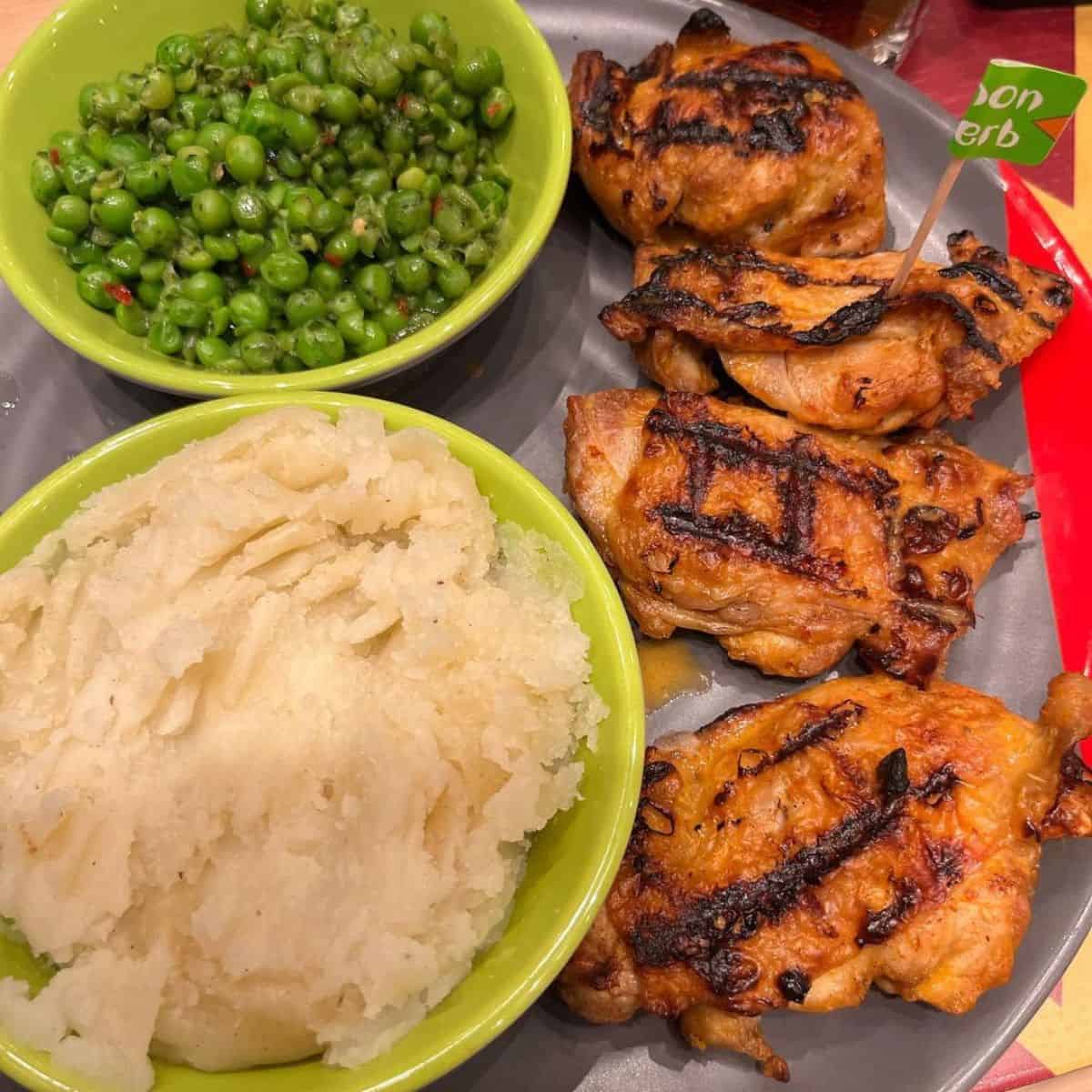 Grilled chicken, mashed potatoes, and green peas