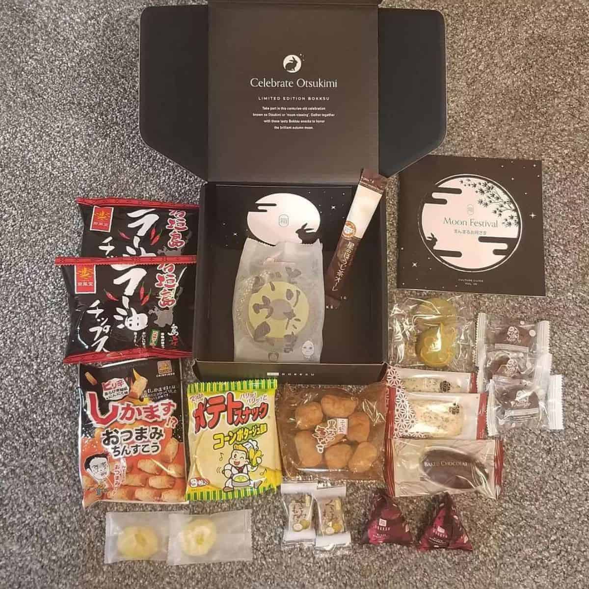 Authentic Japanese munchies surrounding a black Bokksu box