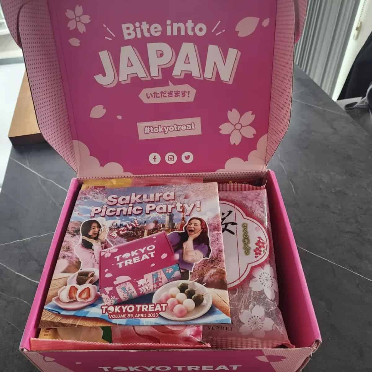 Pink cardboard box with delicious goodies on the marble type table