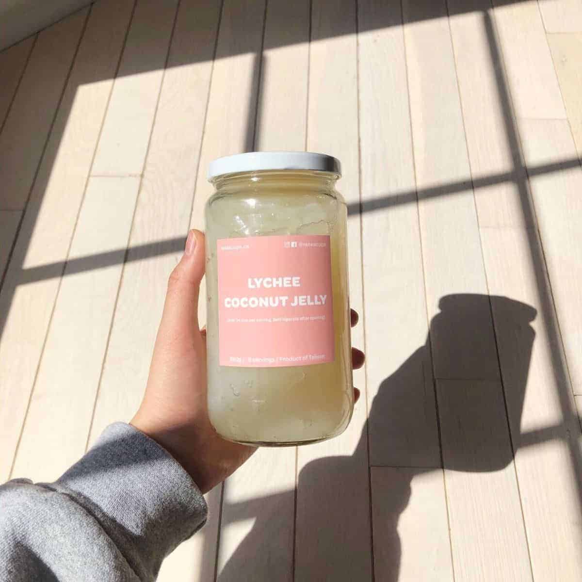 Lychee coconut jelly in a bottle with a pink sticker tag