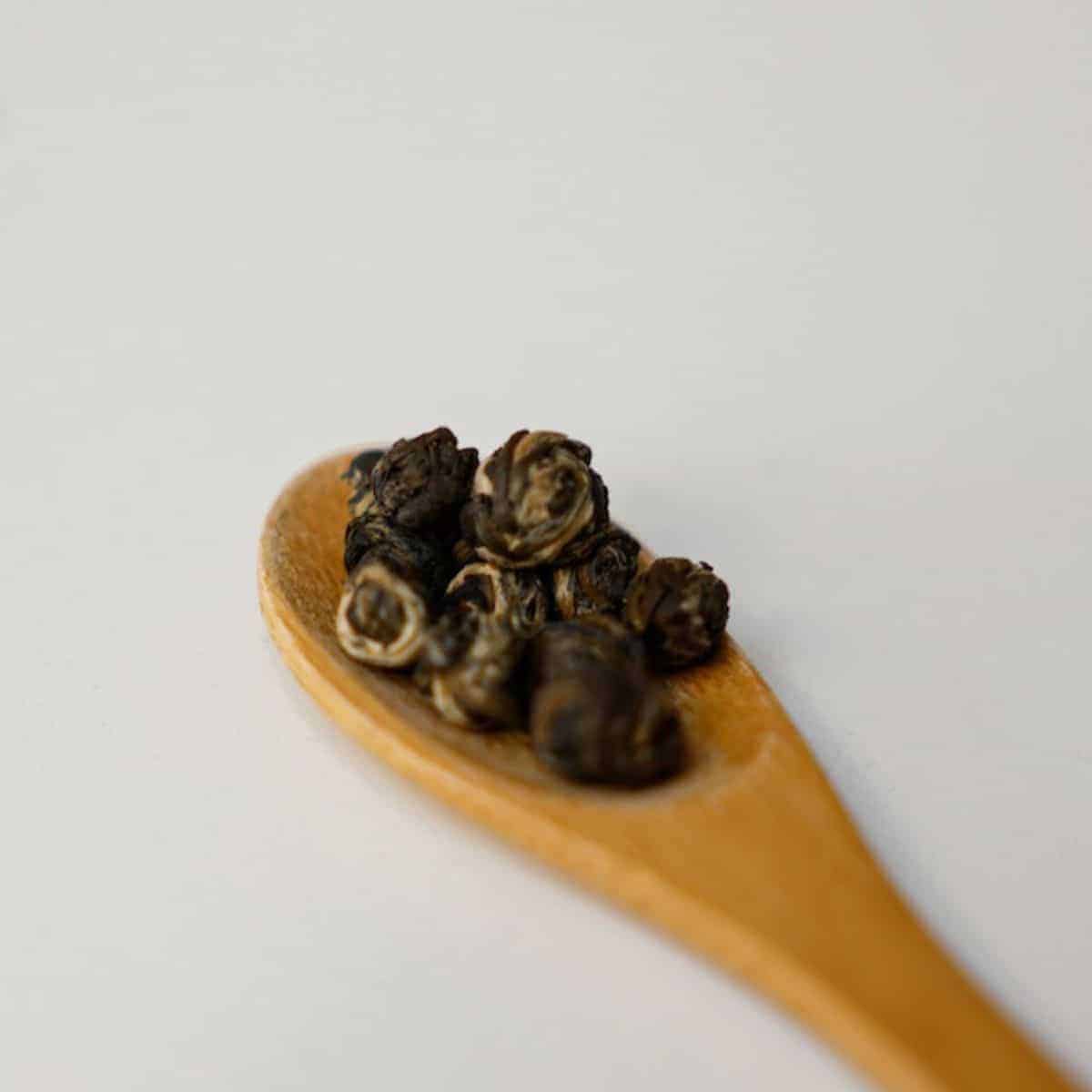 Black peppercorn in a wooden spoon as a Kung Pao Beef ingredient