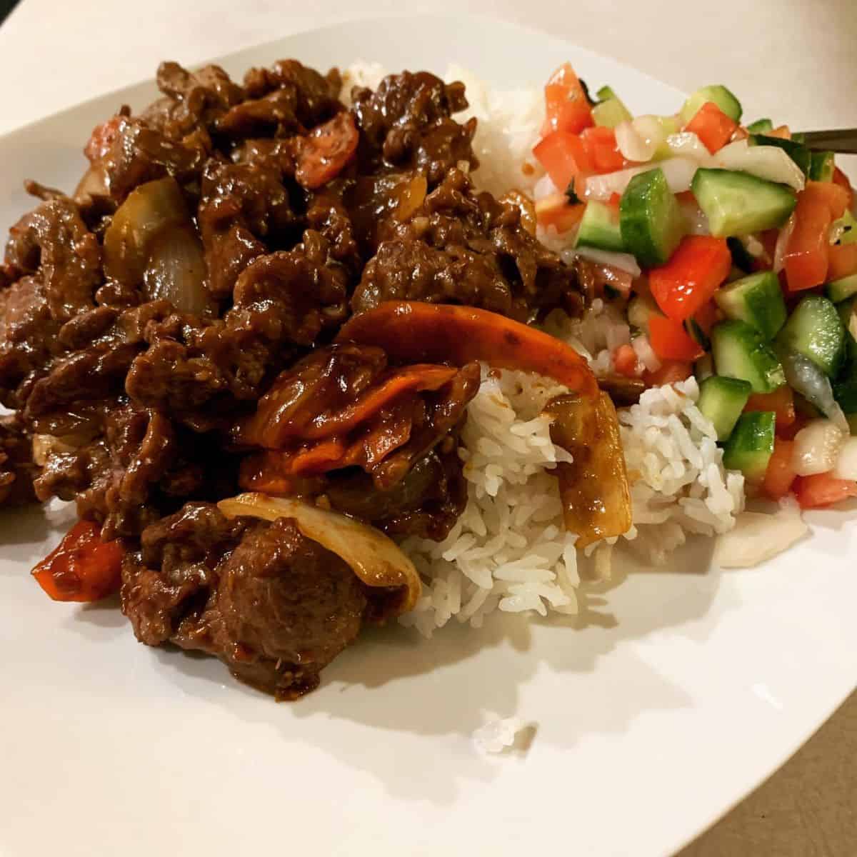 Meaty dish with white rice and a vegetable salad