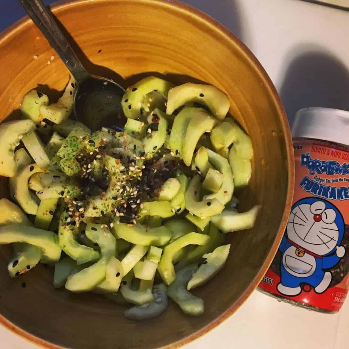 Sunomono with black and white sesame seeds in a brown bowl