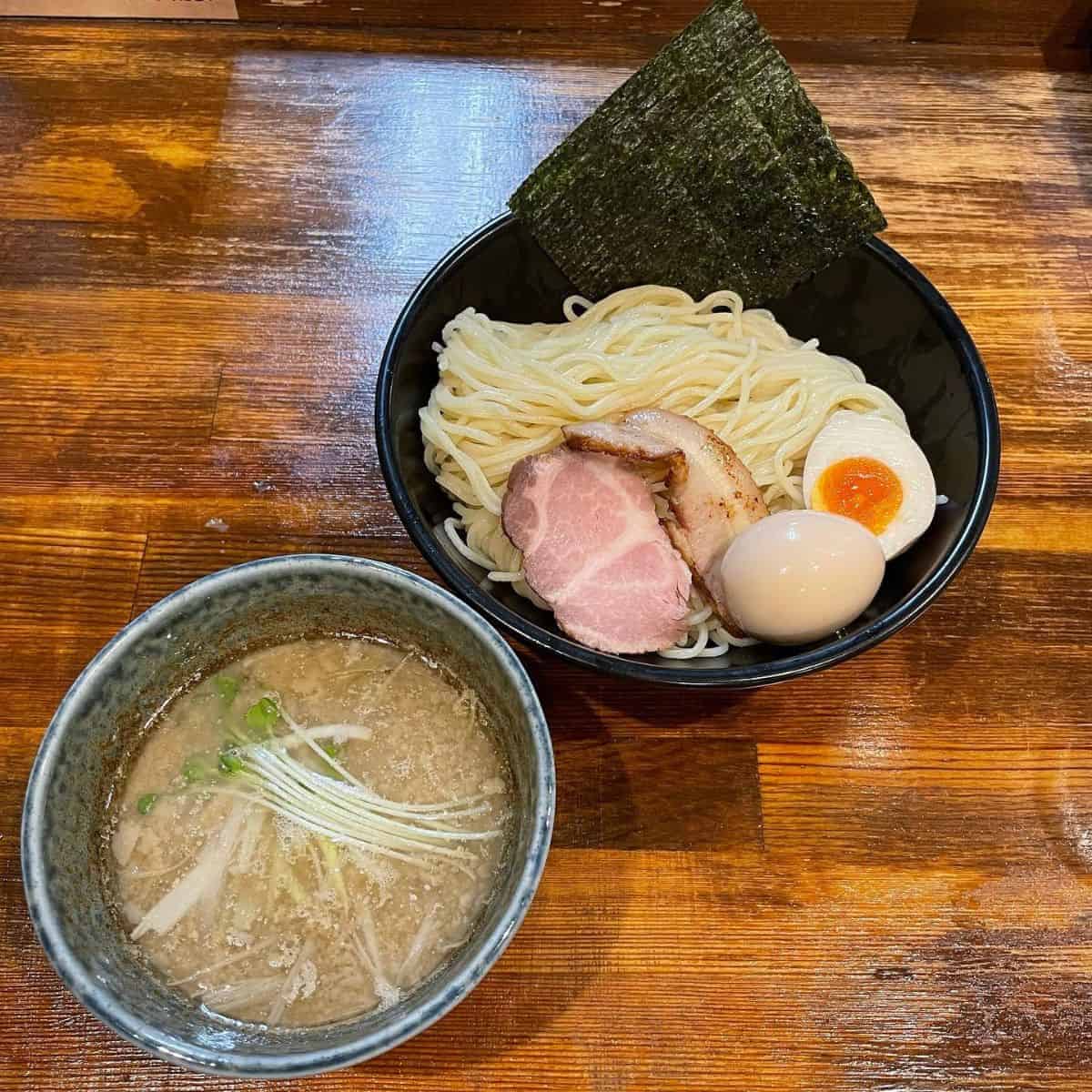 A hot Tsukemen broth and cold noodles with egg and pork