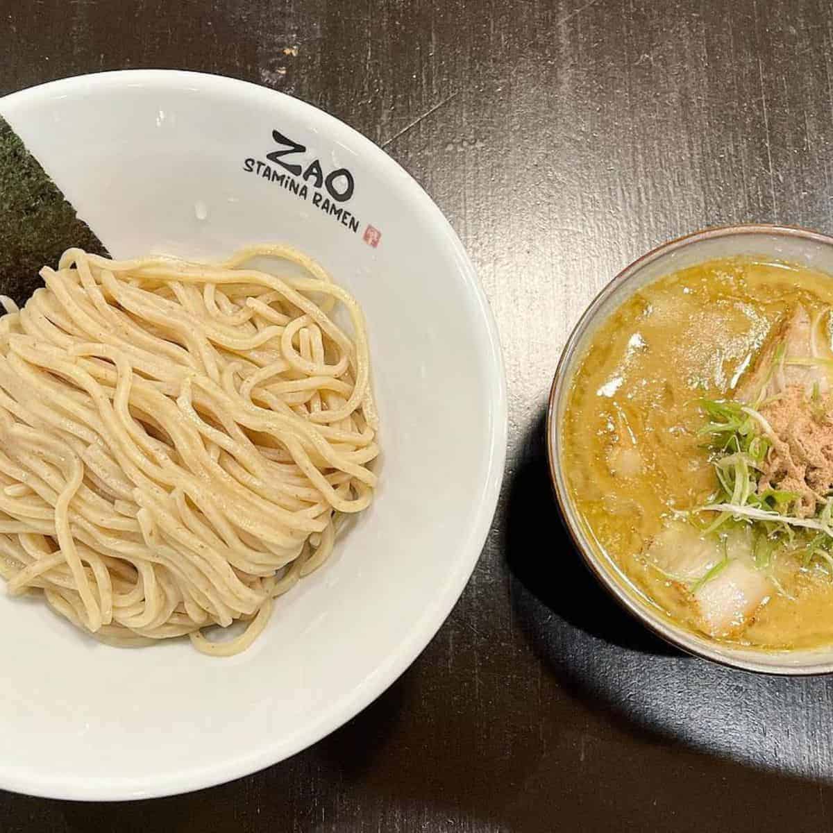 Two white bowls filled with Tsukemen noodles and broth